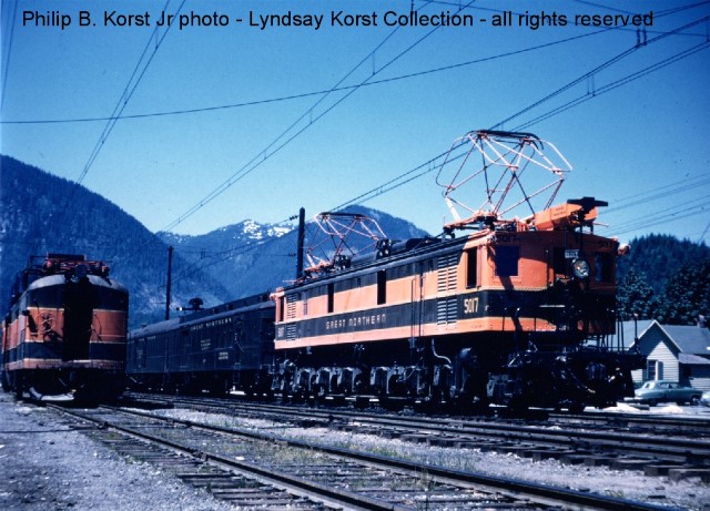 GN 5017 Y-1 class electric locomotive on GN Train #6, The Cascadian at Skykomish, WA.  Note "high car" at left used for maintaining catenary. Philip B. Korst, Jr. photo courtesy GNRHS member Lyndsay Korst. See many more photos at http://www.gngoat.org