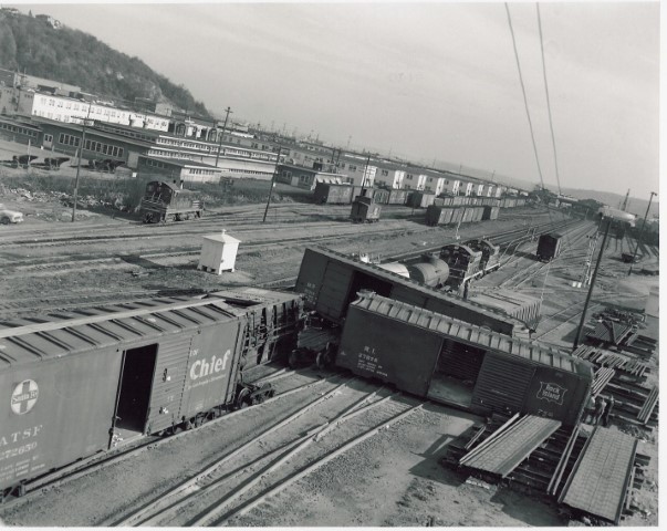 Accident on Interbay yard south lead tracks, at "NP Crossing", NP tracks cross GN from left-to-right to access industries and Navy docks. Small NP yard at left in front of barracks; NP semaphore visible at right. "G yard" in distance. Likely mid-60's.
